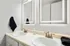 Modern bathroom with dual sinks, elegant gold fixtures, and illuminated mirrors offering chic design and functionality.