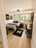 Inviting bedroom with modern decor, featuring a cozy bed, stylish workspace, and large window for abundant natural light.