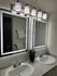 Elegant bathroom with dual sinks, illuminated mirrors, modern lighting, and stylish decor.