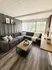Elegant living room featuring a modern gray sectional sofa, chic decor accents, and a large window with ample natural light.