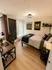 Modern bedroom with cozy decor, featuring a stylish workspace, large window for natural light, and charming university-themed accents.