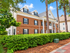 Charming brick apartment building surrounded by lush greenery, offering a serene and inviting residential setting.