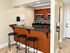 Modern kitchen with sleek granite countertops, rich wood cabinets, and a cozy breakfast bar with stylish stools.
