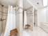 Elegant modern bathroom with two walk-in showers, featuring beige tile, stylish mosaic accents, and convenient wooden shower benches.