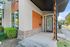 Modern apartment exterior with stylish wood paneling, large windows, and inviting front entrance set in a lush neighborhood.