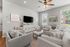 Cozy and inviting living room with stylish gray furniture, large windows offering natural light, and modern decor.