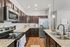 Elegant kitchen with granite countertops, modern appliances, and stylish dark wood cabinets, creating a warm and inviting cooking space.