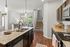 Modern open-concept kitchen and dining area with elegant granite countertops, warm hardwood floors, and abundant natural light.