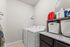 Modern laundry room with sleek washer and dryer, ample shelf storage, and elegant granite countertop.