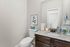 Chic and modern bathroom with elegant granite countertop, tasteful floral decor, and sleek fixtures.