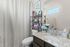 Elegant bathroom with a sleek granite countertop, stylish fixtures, and a decorative shelf adding charm and functionality.