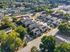 Aerial view of a charming residential neighborhood featuring modern townhouses surrounded by lush greenery and convenient parking spaces.