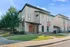 Modern two-story duplex with sleek design and manicured lawn, set in a picturesque neighborhood under a clear blue sky.