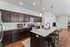 Modern kitchen with elegant dark wood cabinetry, sleek granite countertops, and a contemporary breakfast bar.