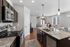 Modern open-concept kitchen with granite countertops and stainless steel appliances, seamlessly connecting to a bright living area with stylish d&eacute;cor.