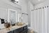 Elegant and modern bathroom featuring granite countertops, stylish accessories, and soft lighting with a chic shower curtain.
