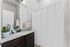 Elegant bathroom with a granite countertop, modern fixtures, and a sleek shower curtain.
