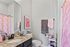 Charming bathroom with a granite countertop, vibrant pink shower curtain, and elegant black fixtures, creating a cozy and stylish ambiance.