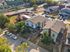 Charming neighborhood aerial view featuring modern townhouses, lush greenery, and convenient access to main roads.