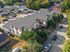 Charming aerial view of a modern townhouse community with sleek roofing, surrounded by lush greenery and vibrant neighborhood life.