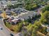 Aerial view of a modern residential neighborhood with stylish housing units surrounded by lush greenery and convenient parking spaces.