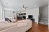 Modern open-concept living space featuring a cozy sectional sofa, stylish dining area, and sleek kitchen with dark wooden cabinetry and bar seating.