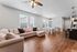 Chic open-plan living space with cozy sectional sofa, elegant dining area, modern kitchen island, and warm wooden floors.