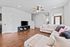 Inviting living room with plush couches, elegant hardwood floors, and a modern ceiling fan in a bright, open space.