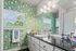 Charming bathroom featuring vibrant floral wallpaper, sleek black countertop, and bright lighting, offering a cozy and stylish ambiance.