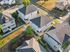 Charming aerial view of a suburban neighborhood showcasing modern single-family homes with well-maintained lawns and inviting pathways.