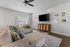 Bright and cozy living room with a large sectional sofa, elegant decor, and a modern entertainment center.