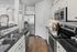 Modern kitchen with sleek black countertops, white cabinetry, and stainless steel appliances, showcasing contemporary elegance.