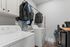 Chic laundry room with modern washer and dryer, stylish coat racks, and ample storage space.