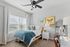 Bright and inviting bedroom with a cozy bed, stylish butterfly art, and elegant furnishings, perfect for relaxation.