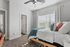 Bright and airy bedroom with modern decor, featuring a plush bed and large window with elegant drapes.
