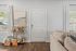 Inviting living space with chic beverage cart, elegant artwork, and soft beige sofa in a cozy apartment entrance.