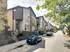 Contemporary townhouse exterior with sleek design and modern facade, nestled in a charming neighborhood street lined with trees.