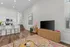 Chic open-concept living space featuring a modern kitchen with a breakfast bar, elegant hardwood floors, and cozy seating area.