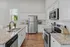 Bright, modern kitchen with sleek granite countertops, classic white cabinetry, and stainless steel appliances creating an inviting cooking space.