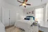 Elegant bedroom with plush blue headboard, cozy white bedding, and stylish ceiling fan, providing a serene retreat.