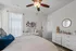 Charming bedroom with elegant decor featuring a cozy bed, stylish ceiling fan, and modern dresser, perfect for creating a peaceful retreat.