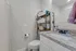 Elegant bathroom featuring modern granite countertop, sleek fixtures, and ample storage with stylish shelving.