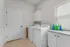 Bright and modern laundry room with energy-efficient appliances, ample cabinetry, and sleek countertops.