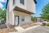 Modern apartment exterior featuring sleek siding and a private entrance, nestled in a vibrant neighborhood with lush greenery and convenient parking.