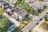 Charming aerial view of a cozy neighborhood showcasing modern townhouses, ample parking, and lush greenery in a serene setting.