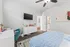 Bright and stylish bedroom featuring modern furnishings, a cozy blue blanket, and a wall-mounted TV for ultimate relaxation.