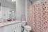 Bright and charming bathroom with granite countertop, playful cocktail-themed shower curtain, and vibrant decor accents.