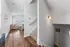 Inviting modern staircase leading to a cozy, light-filled living room with stylish wood flooring and comfortable seating.