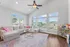 Bright, inviting living room with a spacious L-shaped sofa, colorful accents, natural light from large windows, and chic wooden flooring.