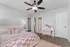 Charming bedroom with cozy bedding and elegant decor, featuring a plush pink throw and a stylish desk in a tranquil setting.